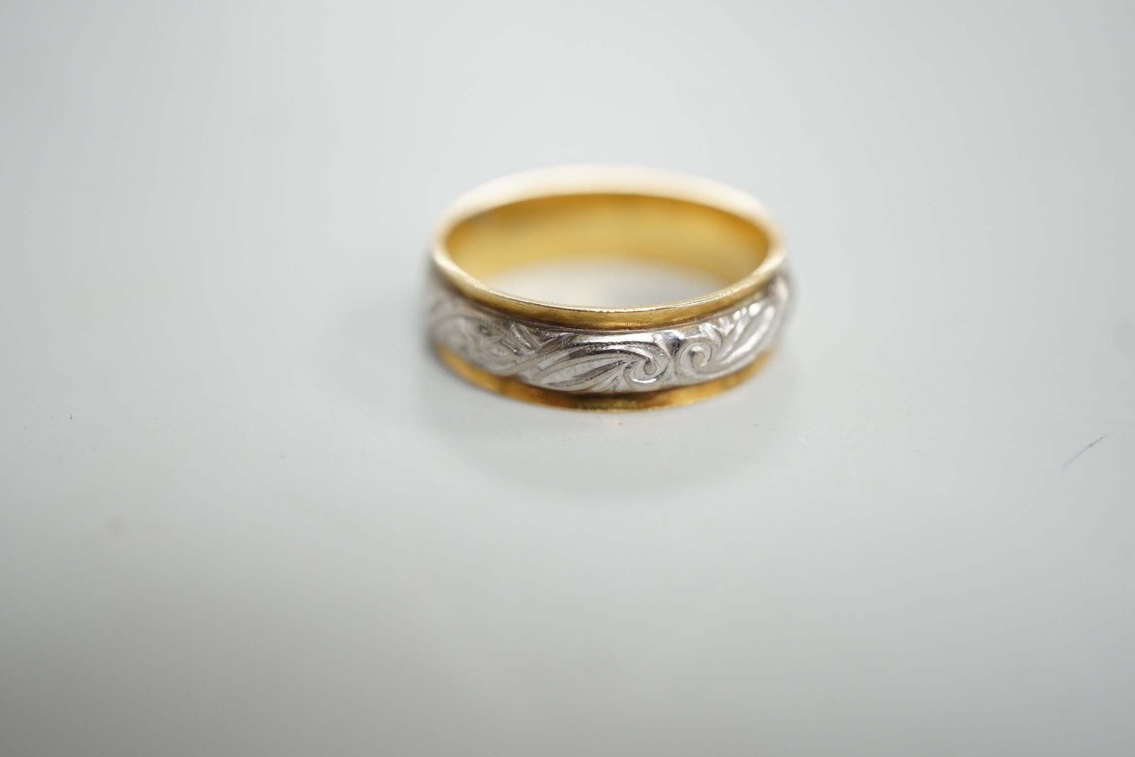 An engraved yellow and white metal band, size L, 3.7 grams.